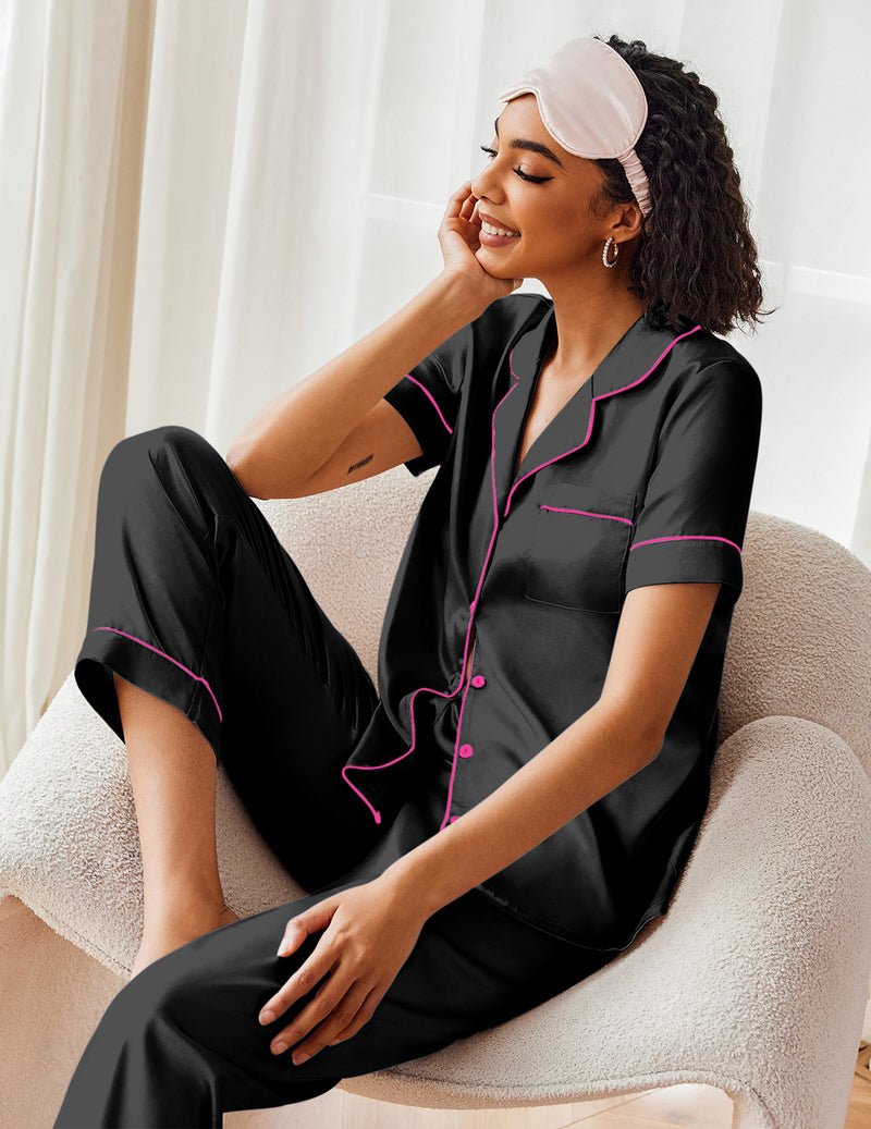 Black satin pajama set with pink trim, short-sleeve button top and matching pants