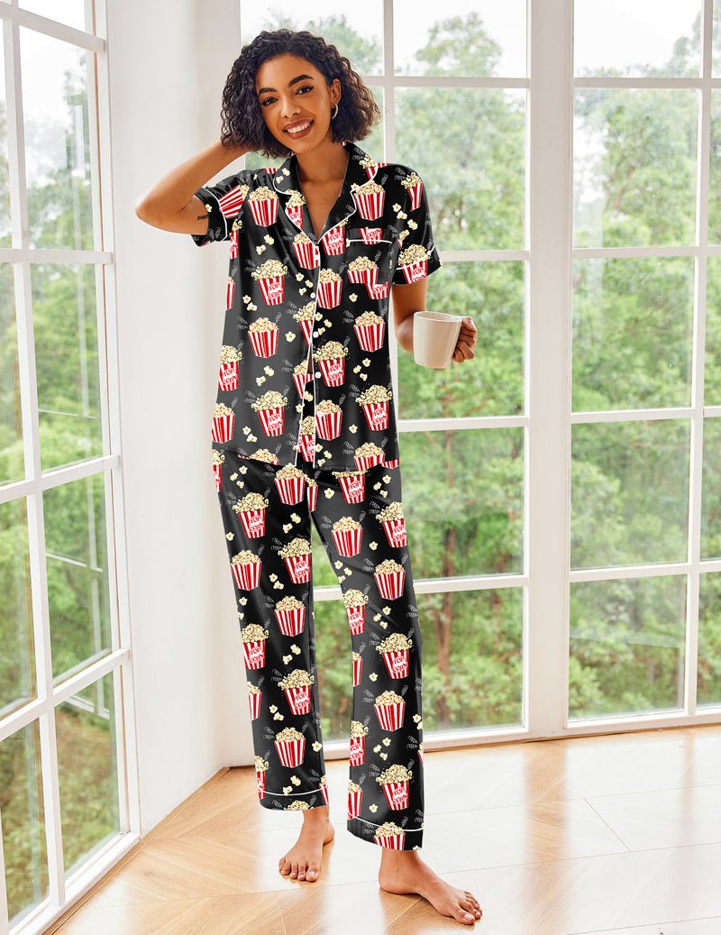 Black satin pajama set with red-and-yellow popcorn print, short sleeves and matching pants