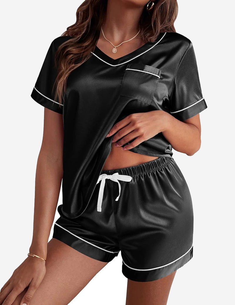 Black satin pajama set with V-neck top and drawstring shorts, contrast trim
