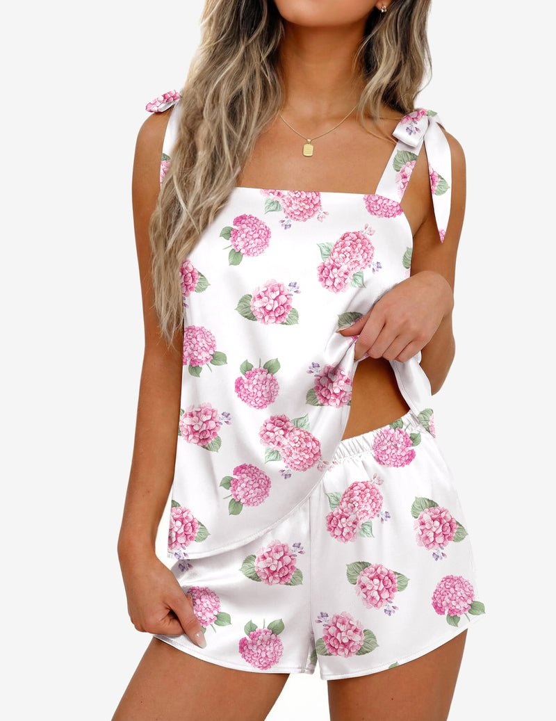 White satin pajama set with pink floral print, bow-tie strap tank top and matching shorts