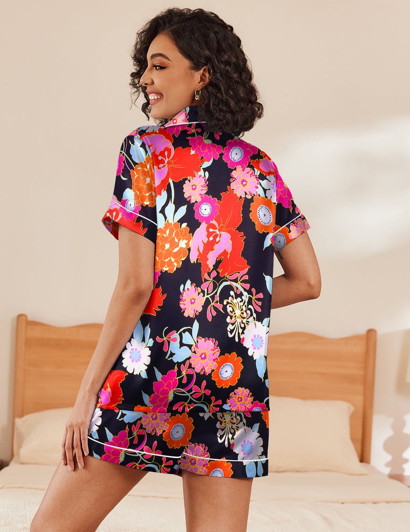 Two-piece silk pajama set with short sleeves and colorful floral print on black