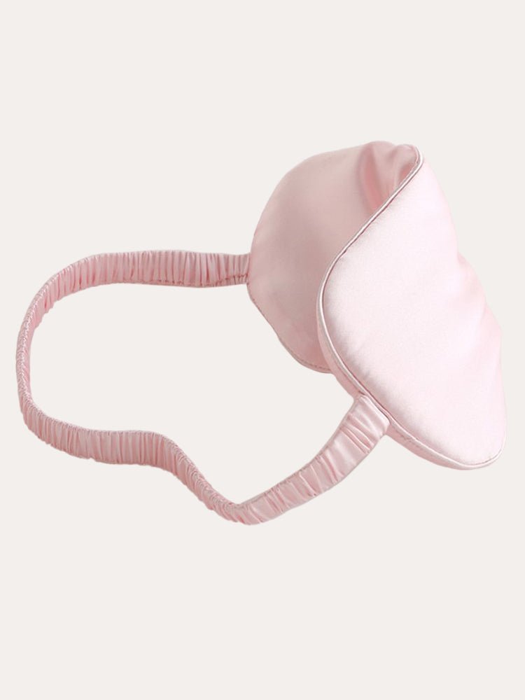 Pink satin sleep eye mask in profile, showing elastic band and seam