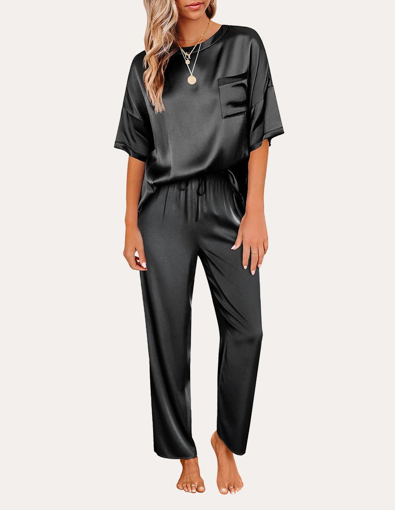 Black satin pajama set: short-sleeve top with chest pocket and drawstring-waist lounge pants.