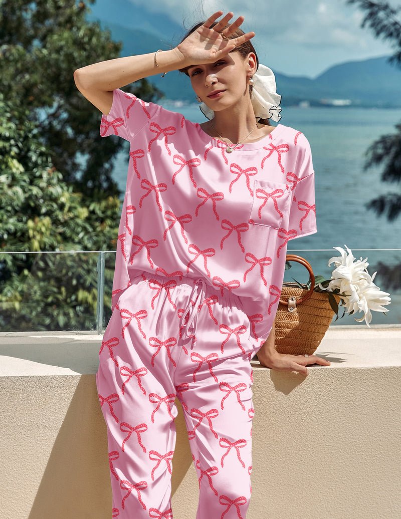 Pink satin lounge set with red bow pattern, ruffled short-sleeve top and tapered pants