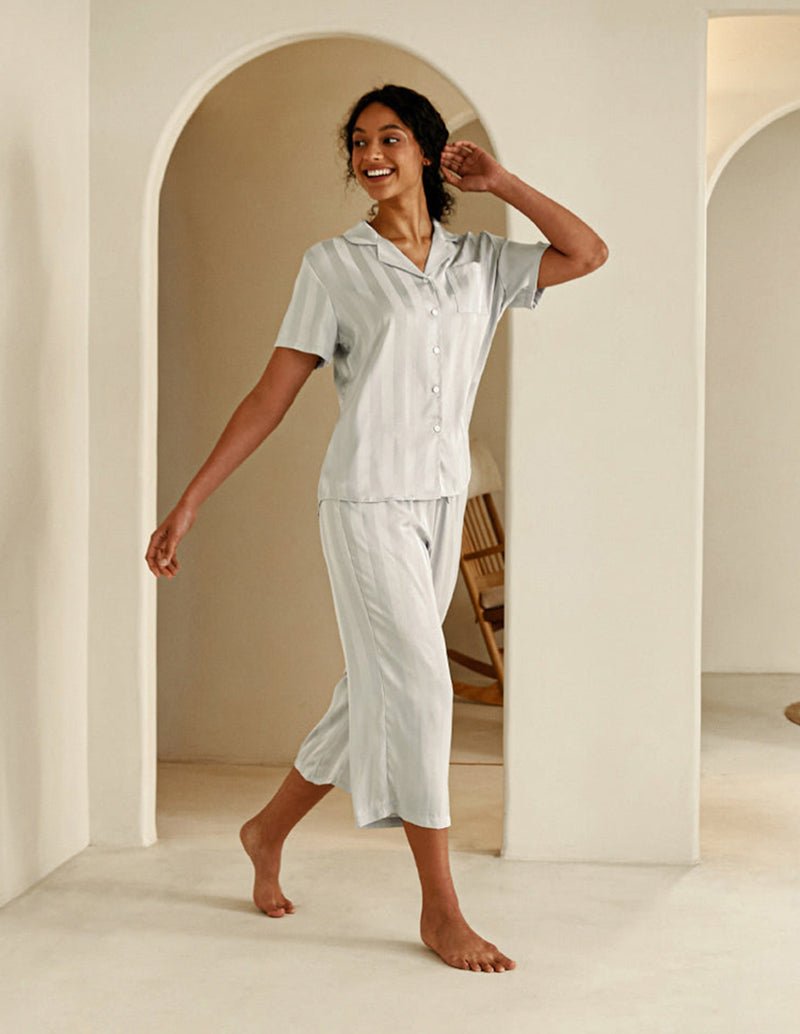 Grey silk satin pajama set with short-sleeve button-down top and cropped pants