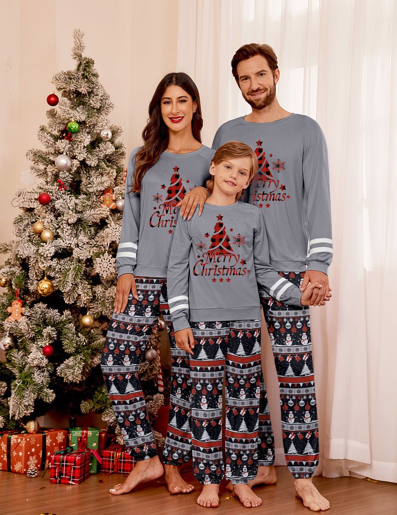 Family in grey Christmas pajamas with red tree front graphic and patterned pants