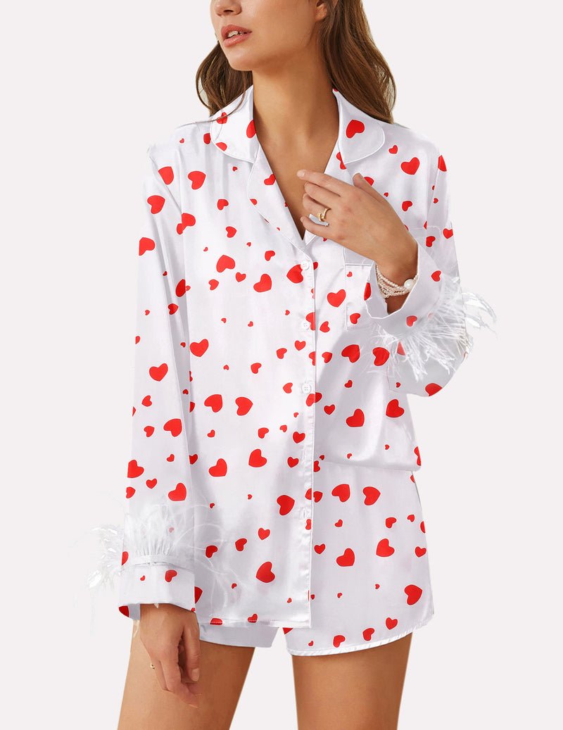 White satin pajama set with red heart print, feather-trim cuffs, button front top.
