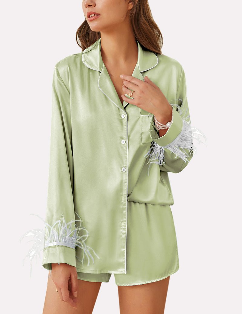 Light green satin pajama set with feather-trim cuffs and button front top, matching shorts.