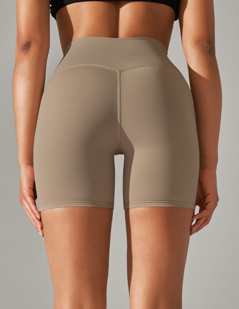 Beige high-waist stretch yoga shorts, back view with vertical seam