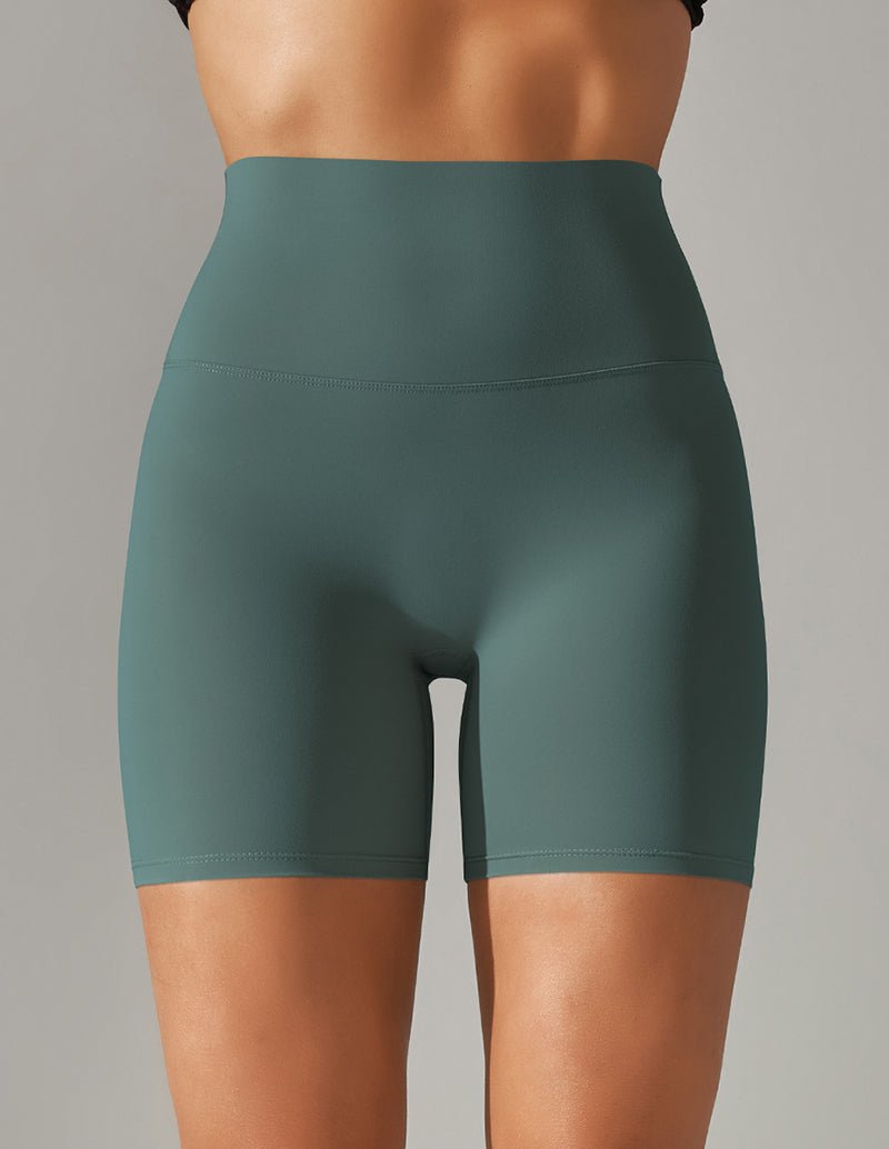 High-waisted stretch yoga shorts in green, mid-thigh length.