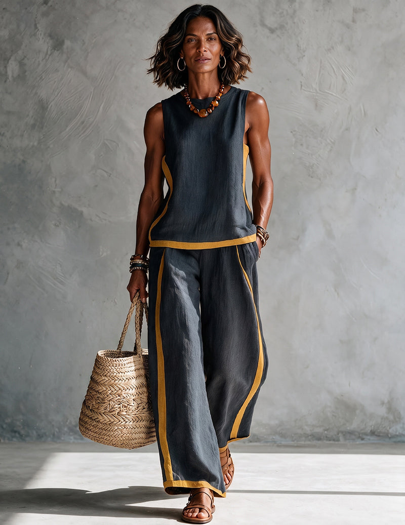 Dark charcoal sleeveless top and wide-leg pants set with gold trim at neckline and cuffs