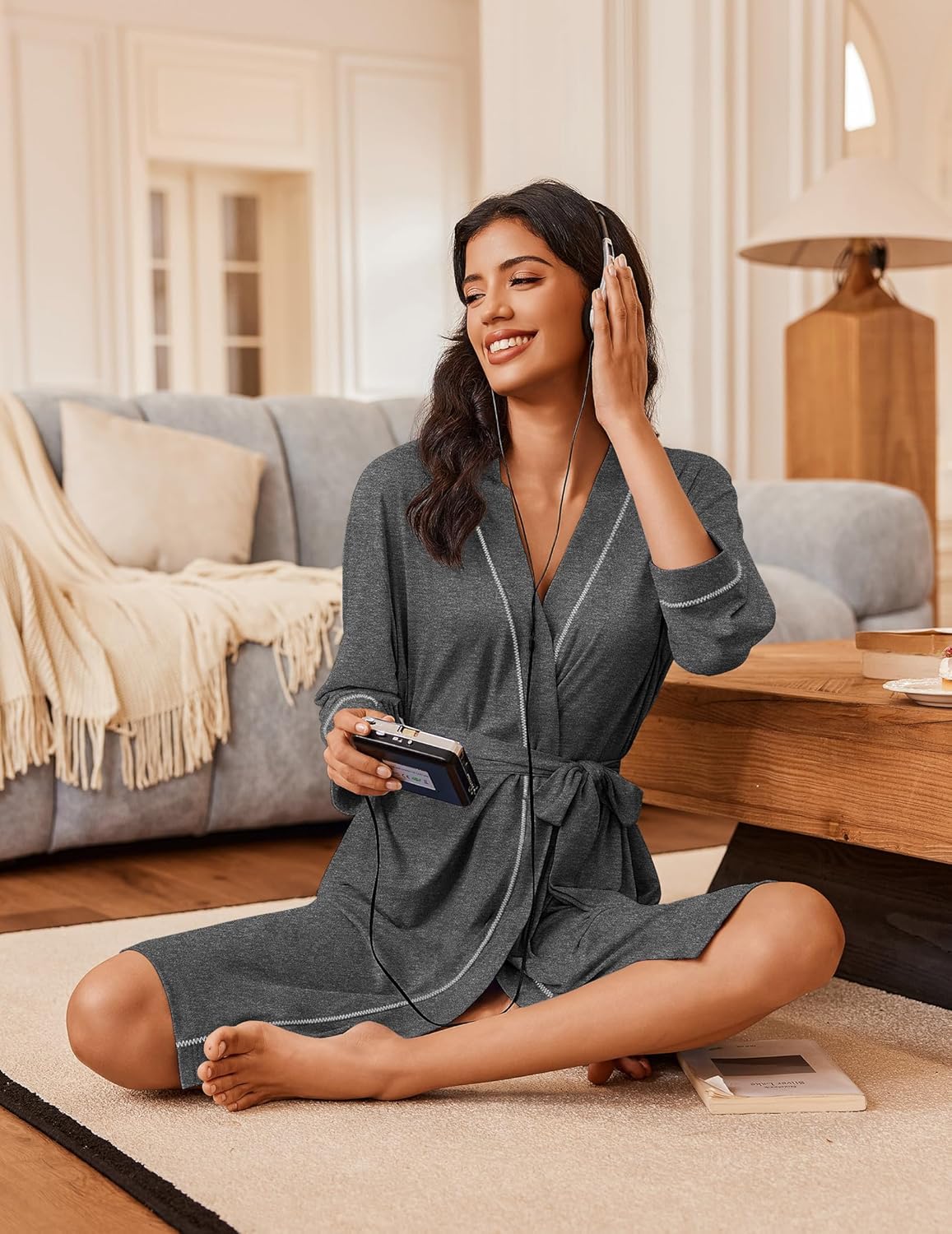 Dark gray wrap bathrobe with 3/4 sleeves and tied waist, contrast trim; seated pose