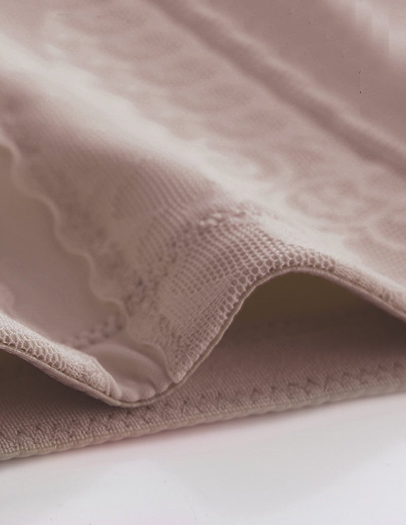 Beige lace-trim shapewear fabric close-up with scalloped edge and seam detail