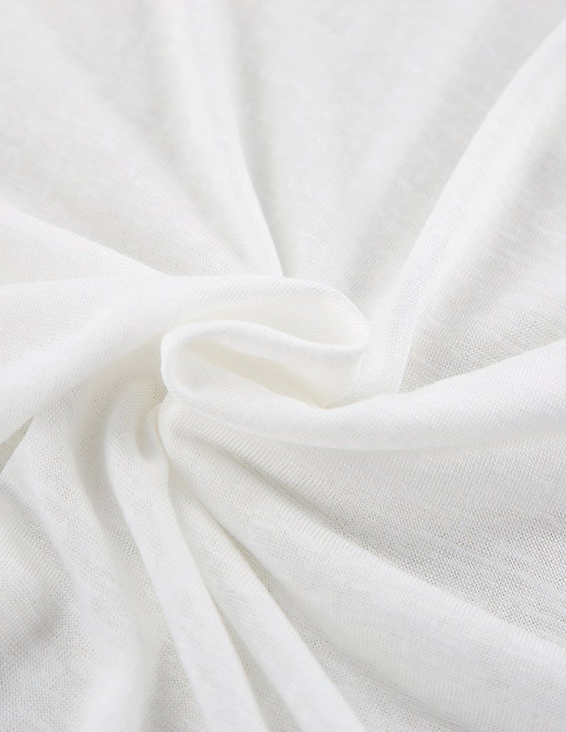 White knit fabric close-up with soft gathered folds
