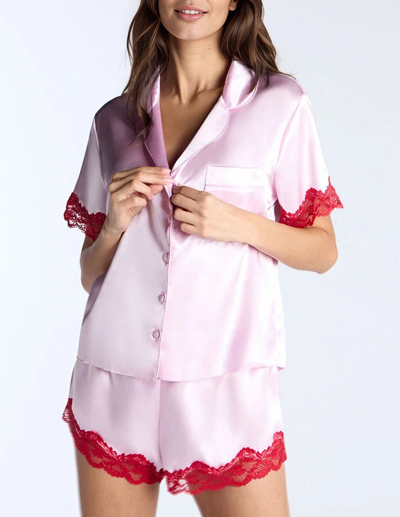 Pink satin pajama set with contrast lace trim, button-front top and matching shorts
