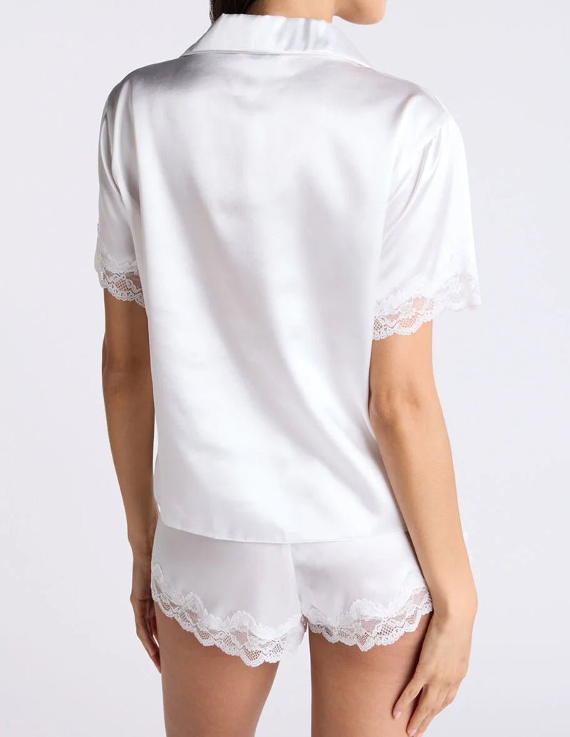 White satin pajama set with lace-trim collar top and matching lace hem shorts
