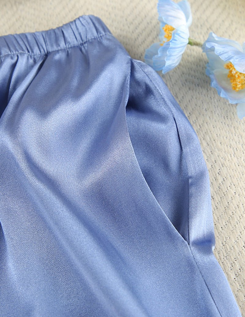 Blue satin pajama pants with elastic waistband and smooth front panel