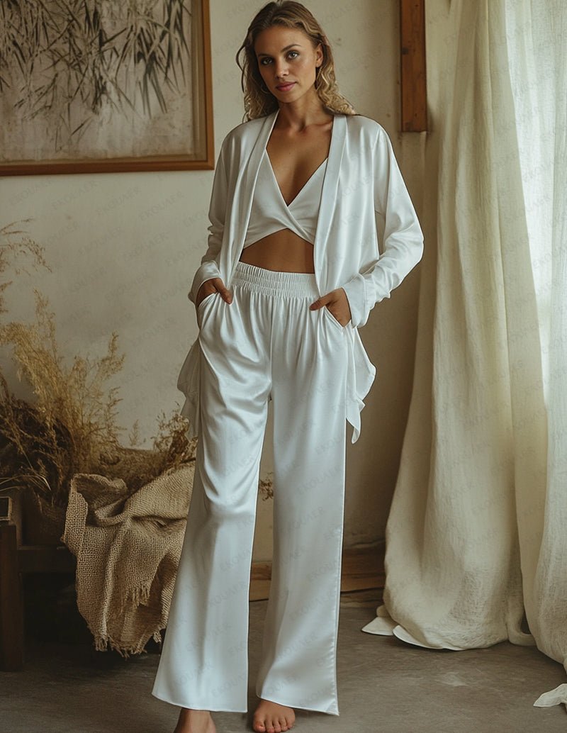 White satin lounge set with V-neck bralette, open long-sleeve top, and wide-leg pants