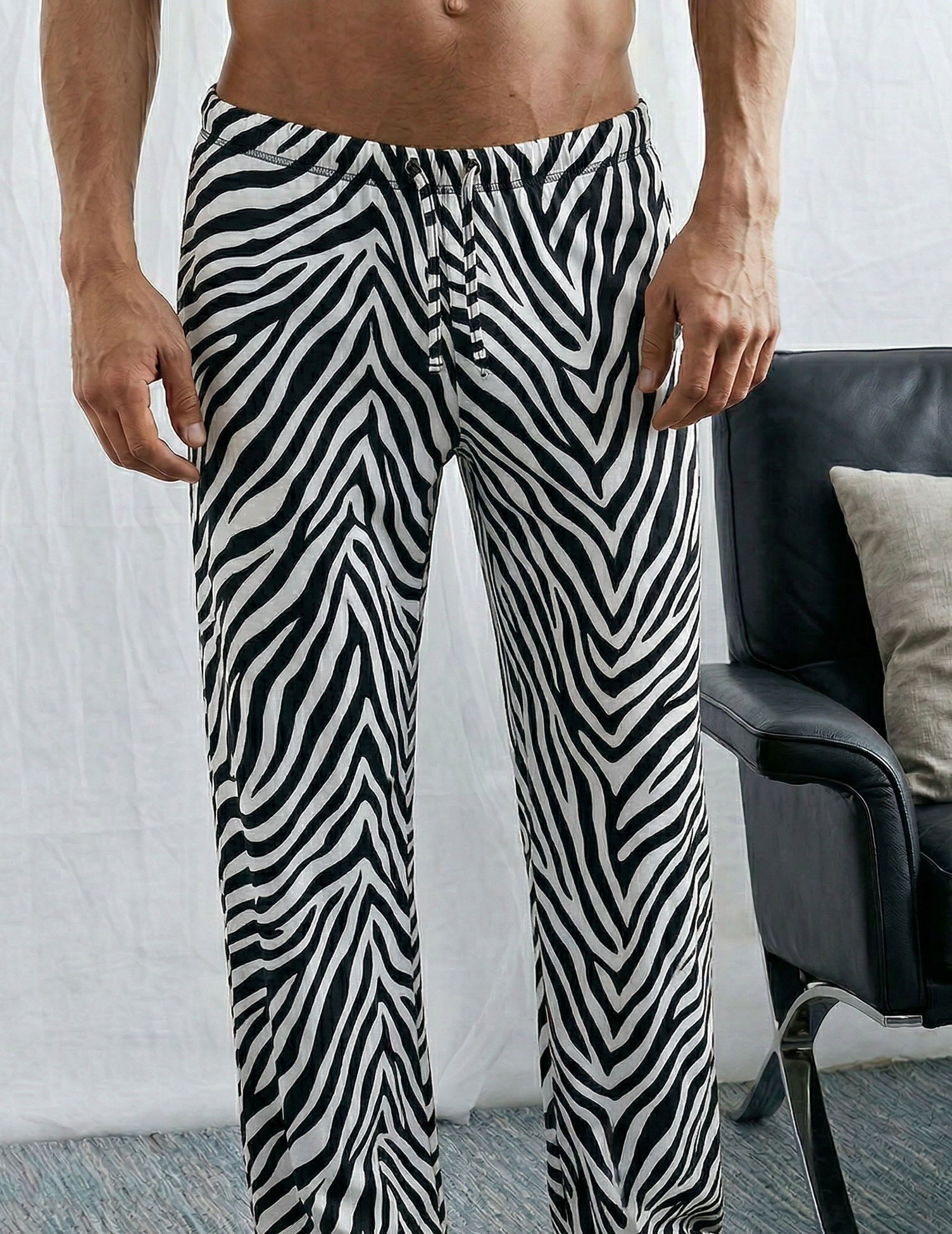Men's lounge pants, black zebra stripes, drawstring waist, tapered legs.