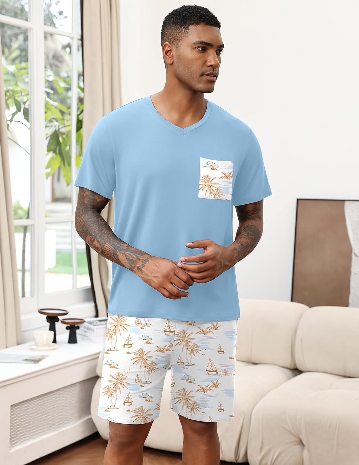 Light blue men's pajama set with tropical pocket print and patterned shorts.
