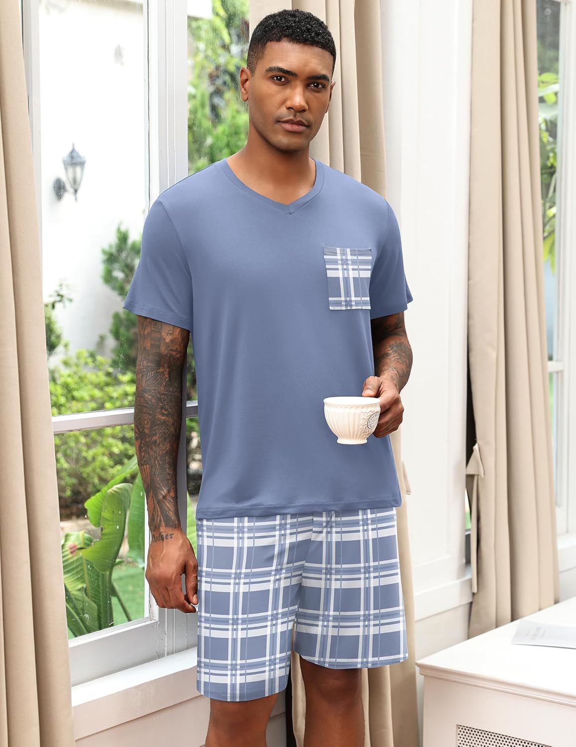 Light blue men's V-neck pajama set with plaid shorts and chest pocket print.