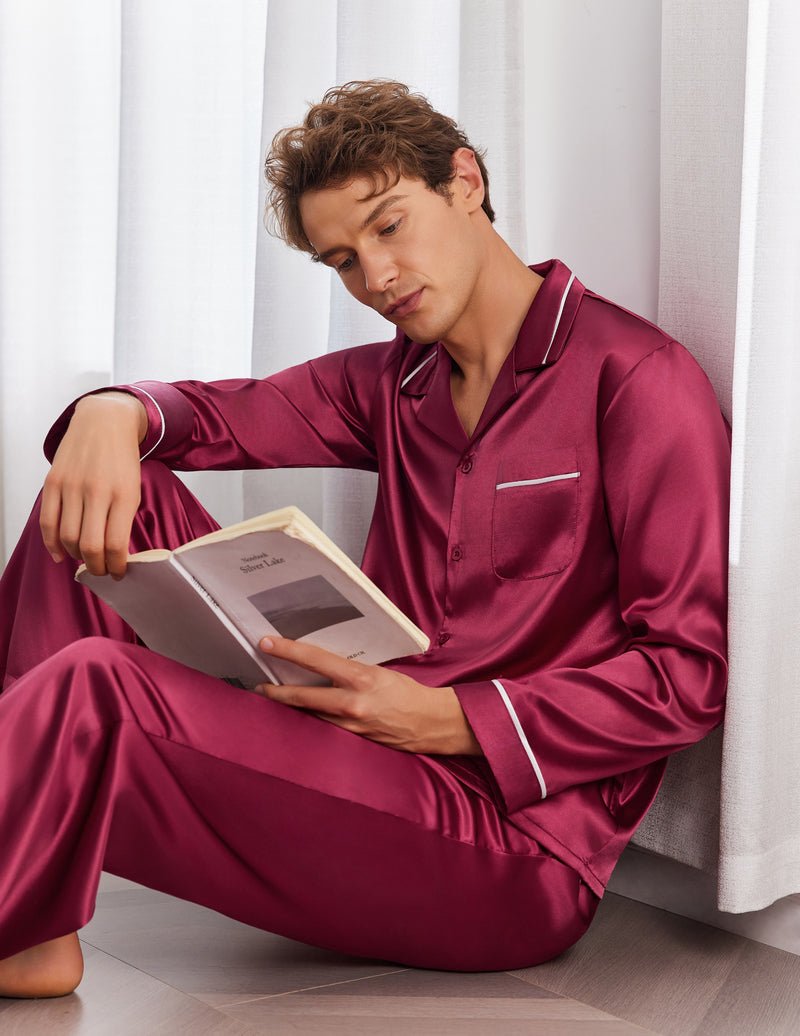 Wine-red satin pajama set: long-sleeve button shirt and relaxed long pants, seated