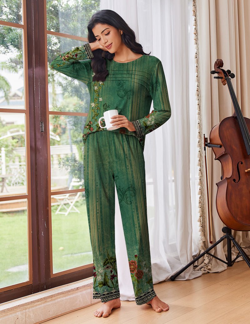 Green printed pajama set with long sleeves and long pants; holding a mug