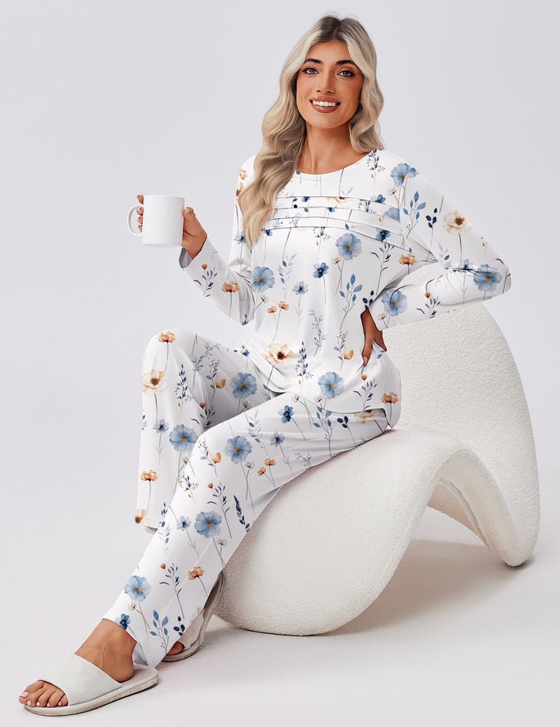 White floral pajama set with long sleeves and long pants; holding a mug