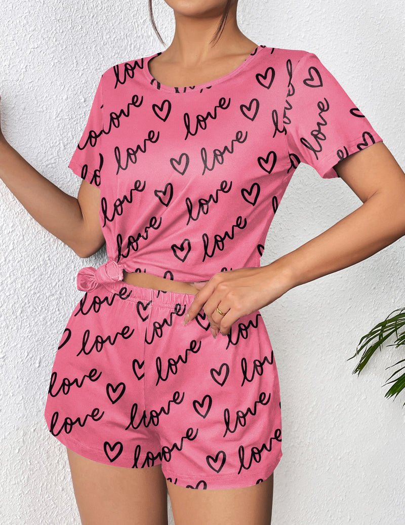 Pink pajama set with black “love” script and heart pattern, short-sleeve top and shorts