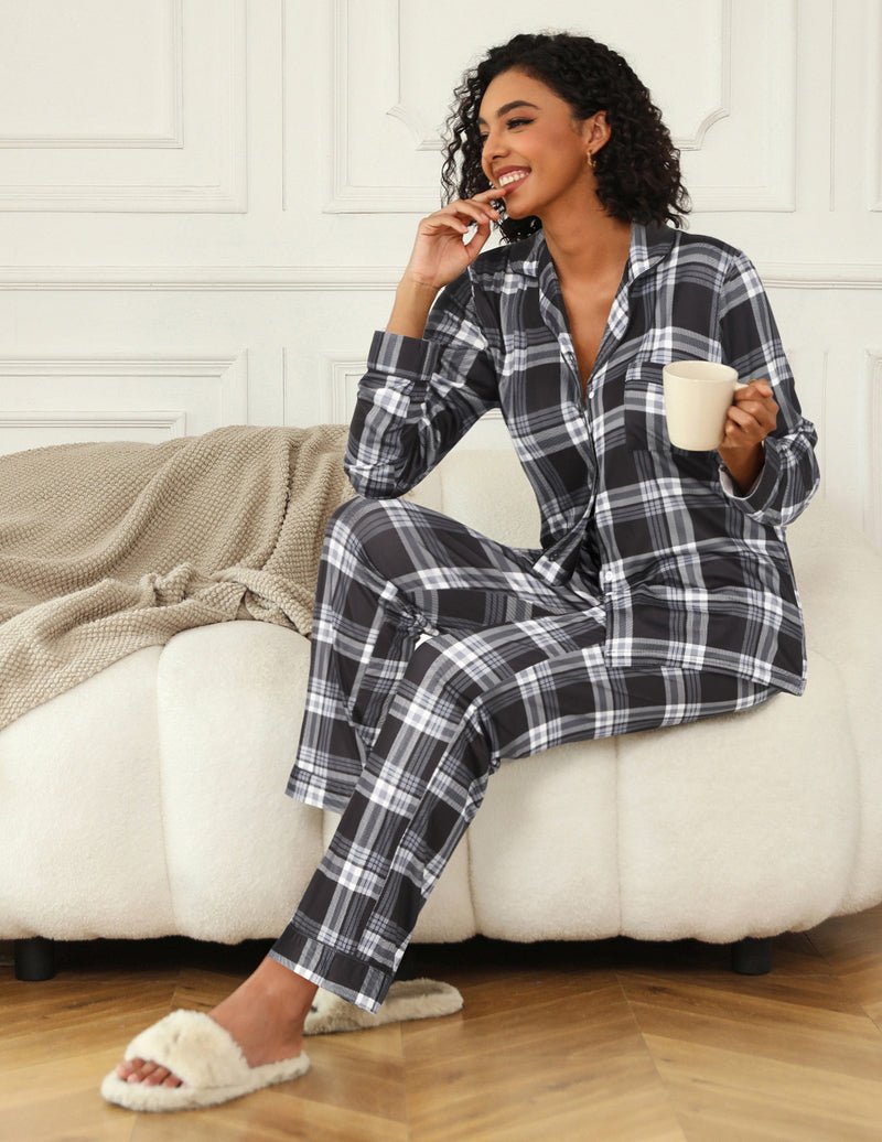 Dark plaid pajama set with button-up top and matching pants, side-sitting pose