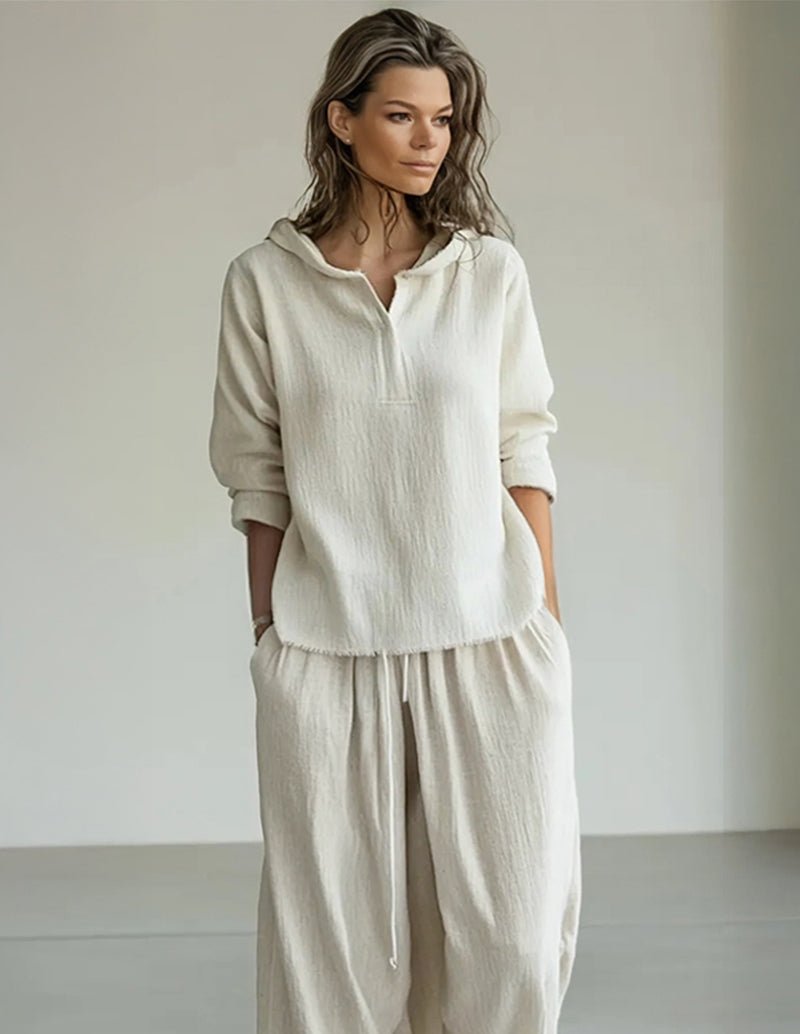 White lounge set: hooded pullover with gathered hem and wide-leg pants.