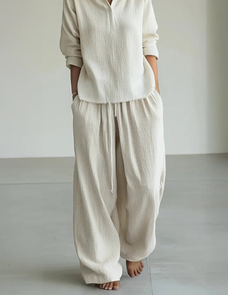 White drawstring lounge pants with elastic waistband and relaxed tapered legs.