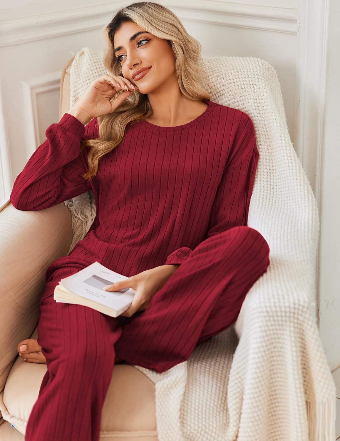 Wine red ribbed knit pajama set: long-sleeve top and wide-leg pants, seated.