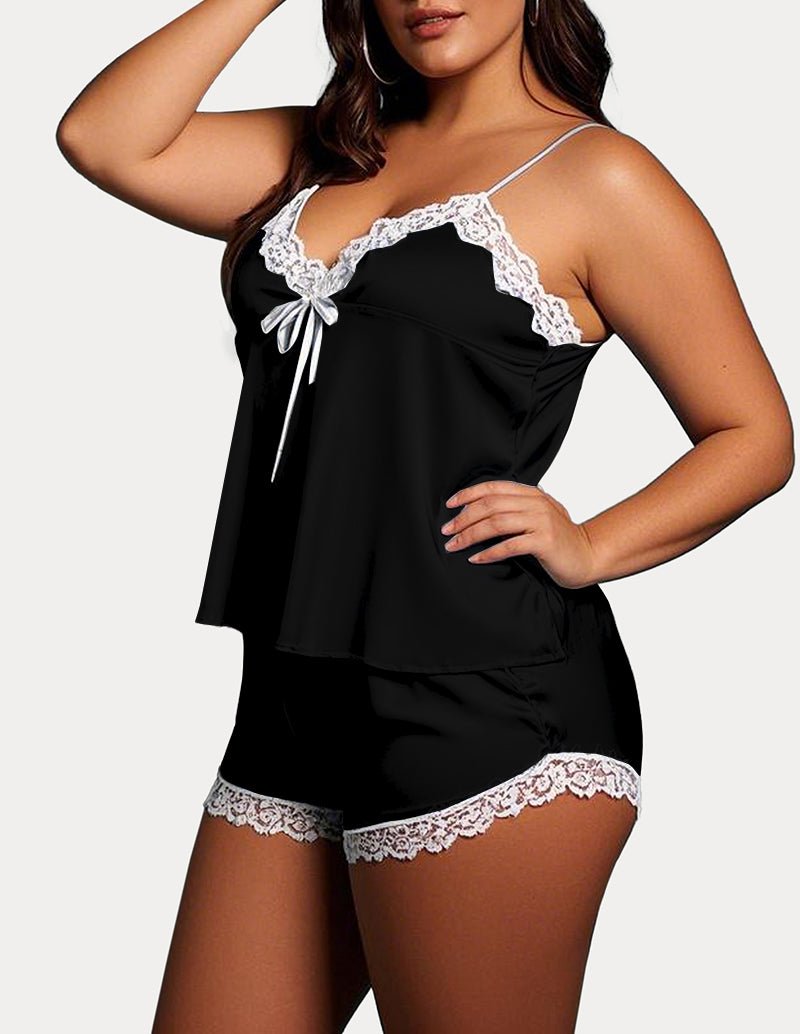 Black satin camisole and shorts pajama set with white lace trim and tie straps.