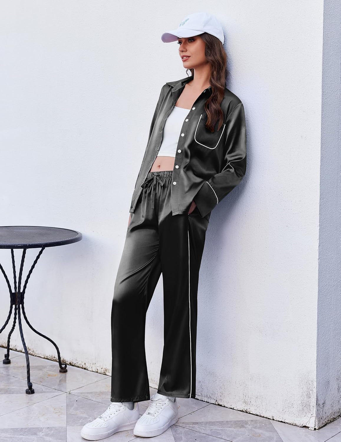Black satin lounge pajama set with button-front top, pocket detail, and long pants