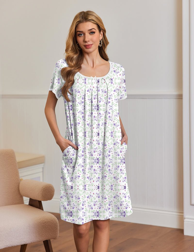 White short-sleeve house dress with small purple floral pattern, side pockets and pleated yoke