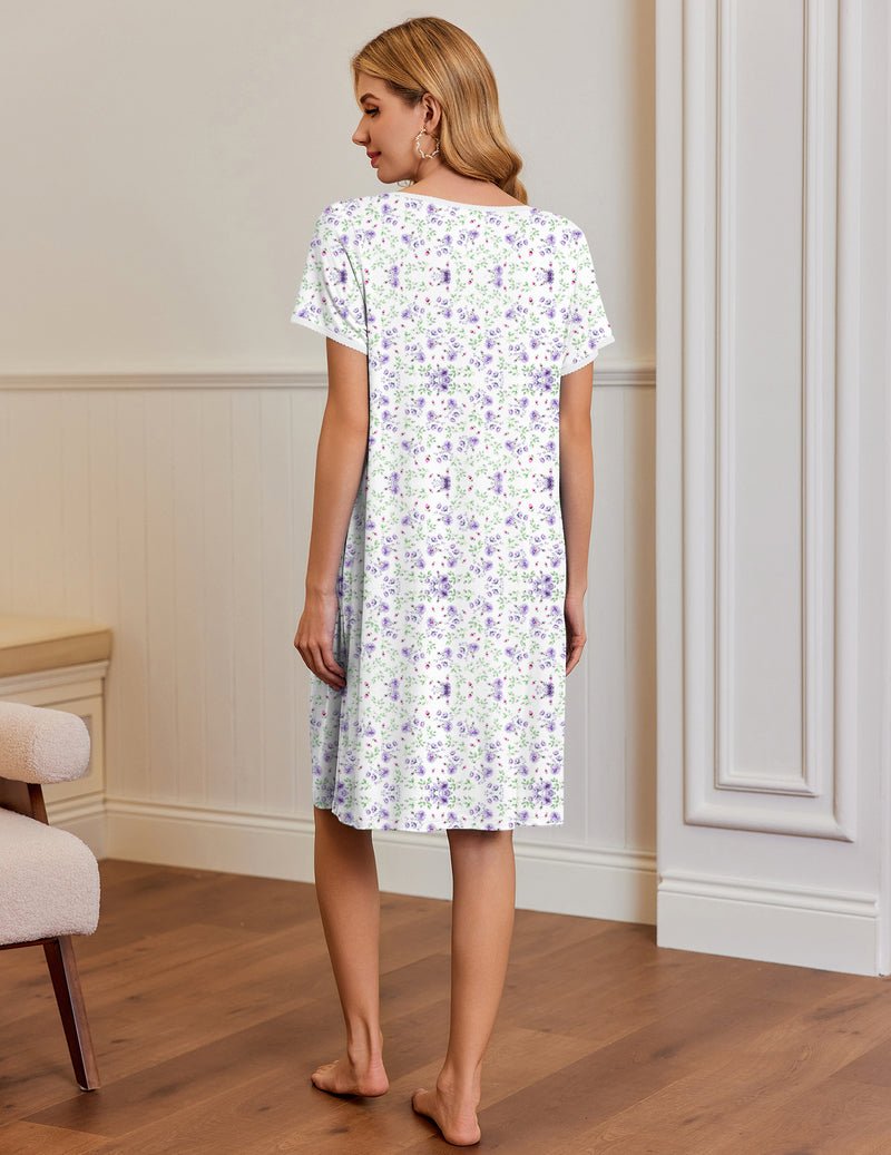 White-and-purple floral short-sleeve house dress, back view; side pockets and pleated yoke