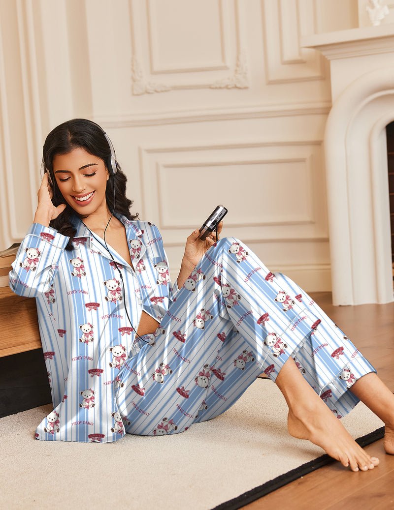 Blue teddy bear pajama set with button-front top and long pants while lounging indoors