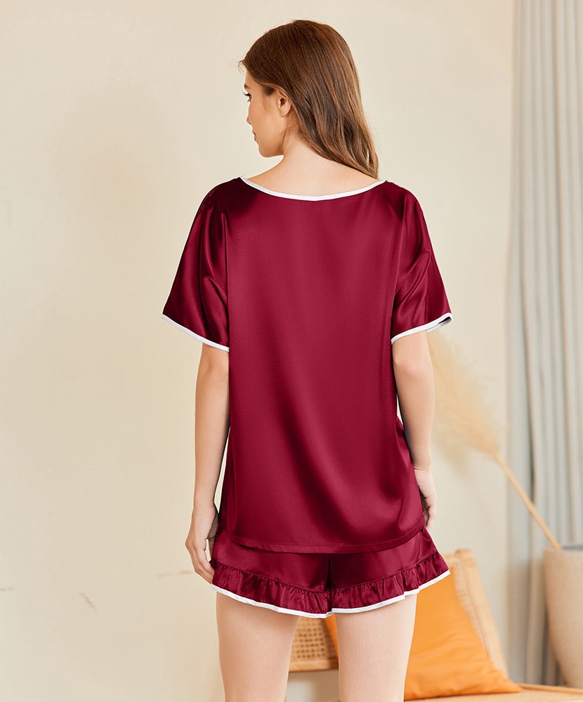 Silk sleepwear top with wine red satin finish and contrast trim, with ruffle shorts visible