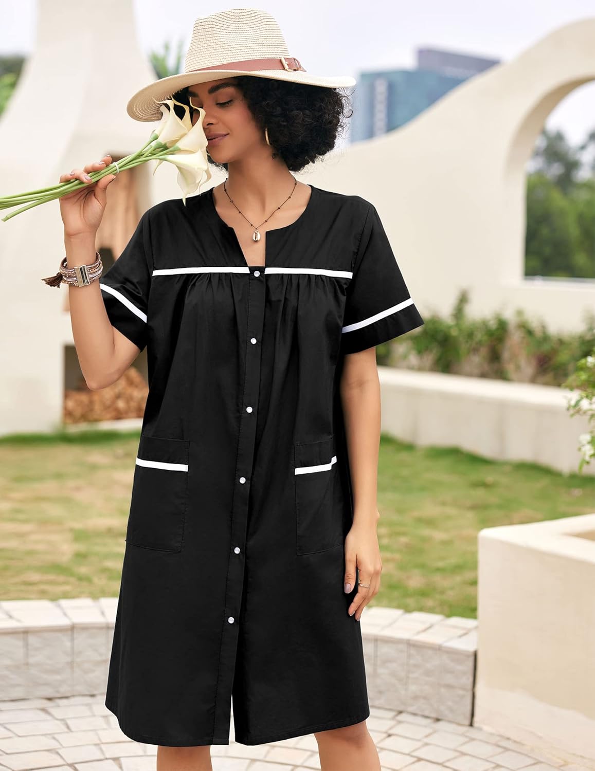 Black cotton snap-front house dress with short sleeves and white trim pockets