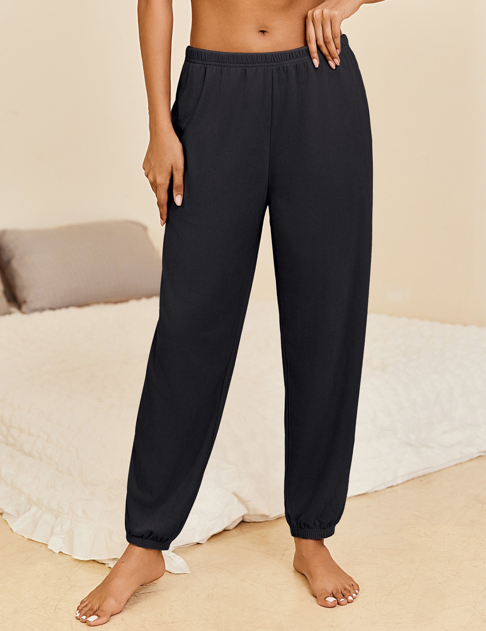 Black lounge pants with elastic waistband and cuffed ankle hems, relaxed fit