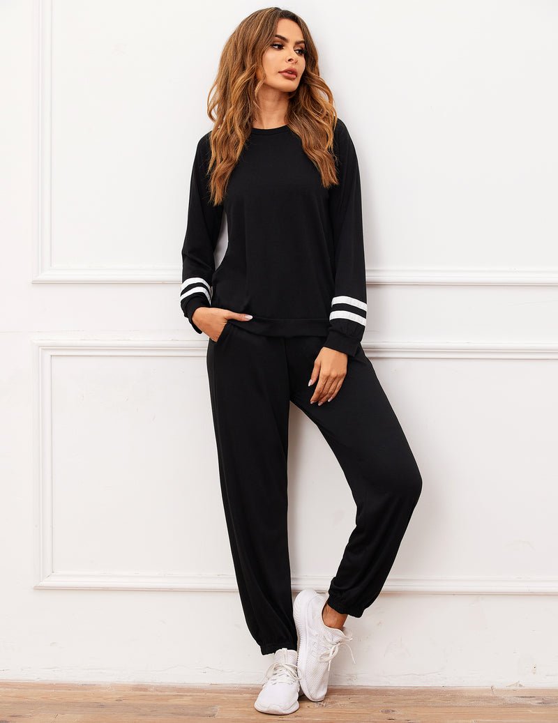 Black 2-piece pajama set with long sleeves, white striped cuffs, and drawstring jogger pants