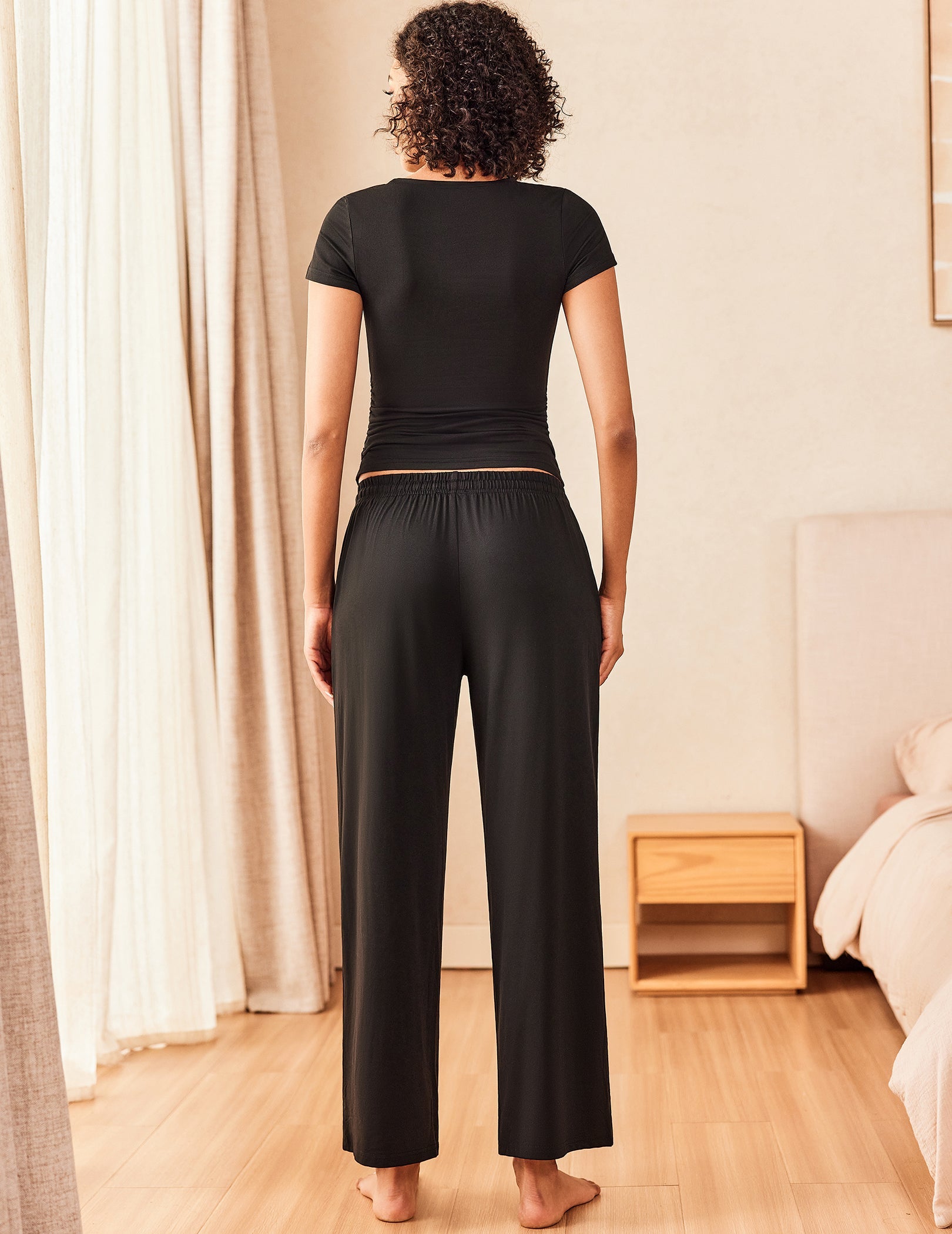 Super soft lounge set in black: back view short-sleeve fitted top with wide-leg drawstring pants.