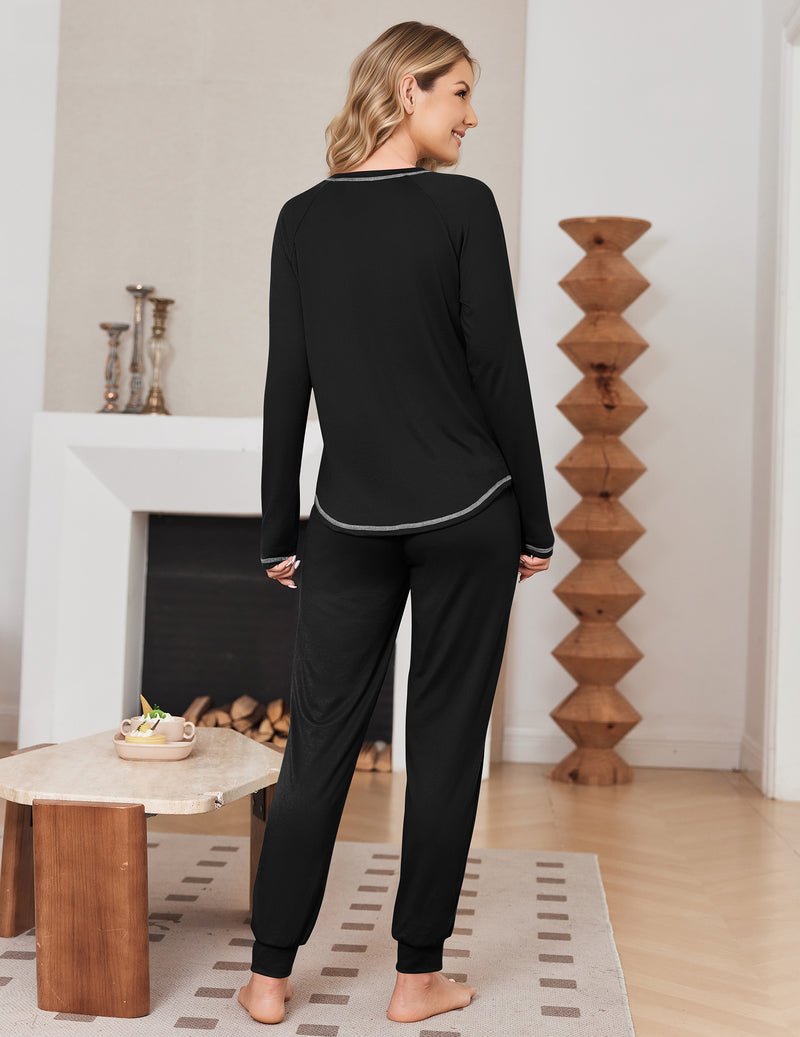 Back view of solid black long-sleeve pajama top and jogger pants with contrast trim