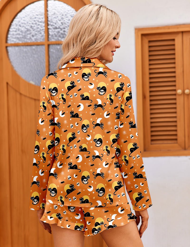 Orange satin pajama set with long sleeves and cat skull pattern, ruffle hem shorts