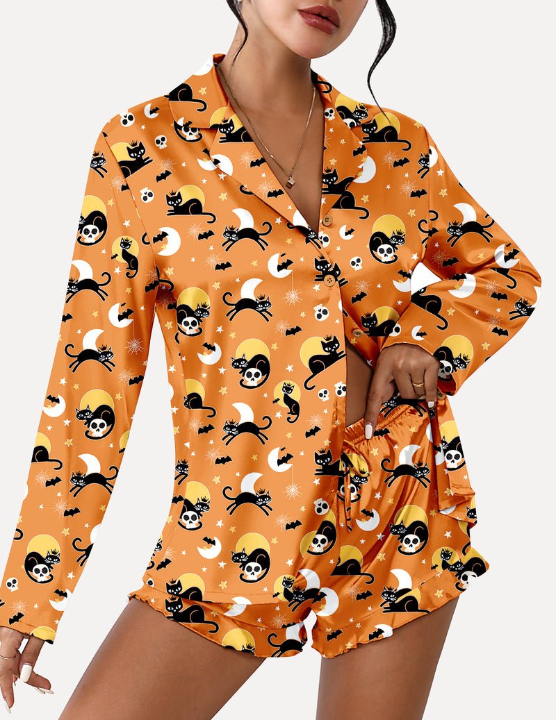 Orange satin pajama set with long sleeves and cat skull graphic, ruffle hem shorts