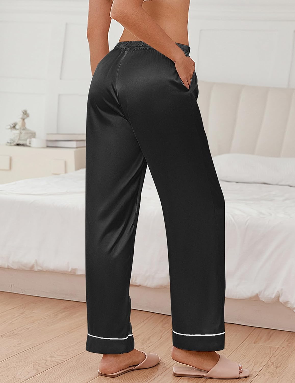 Black satin pajama pants with elastic waistband and contrast trim at cuffs and hem.