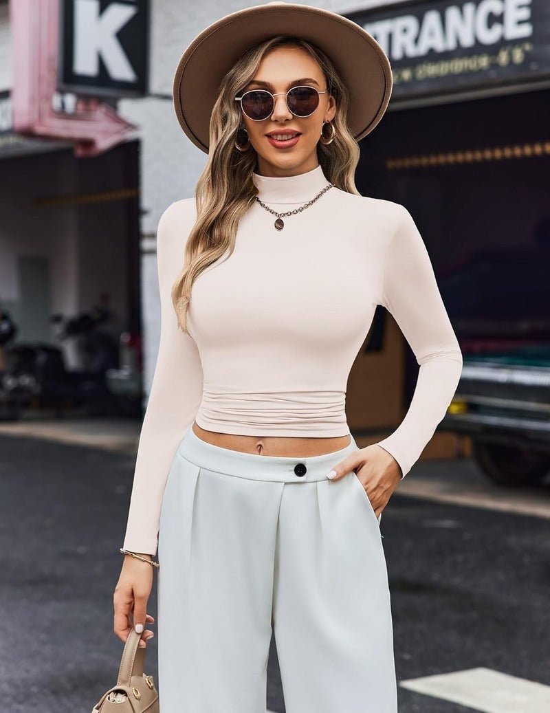 White long-sleeve turtleneck thermal top, fitted with ruched waist detail.