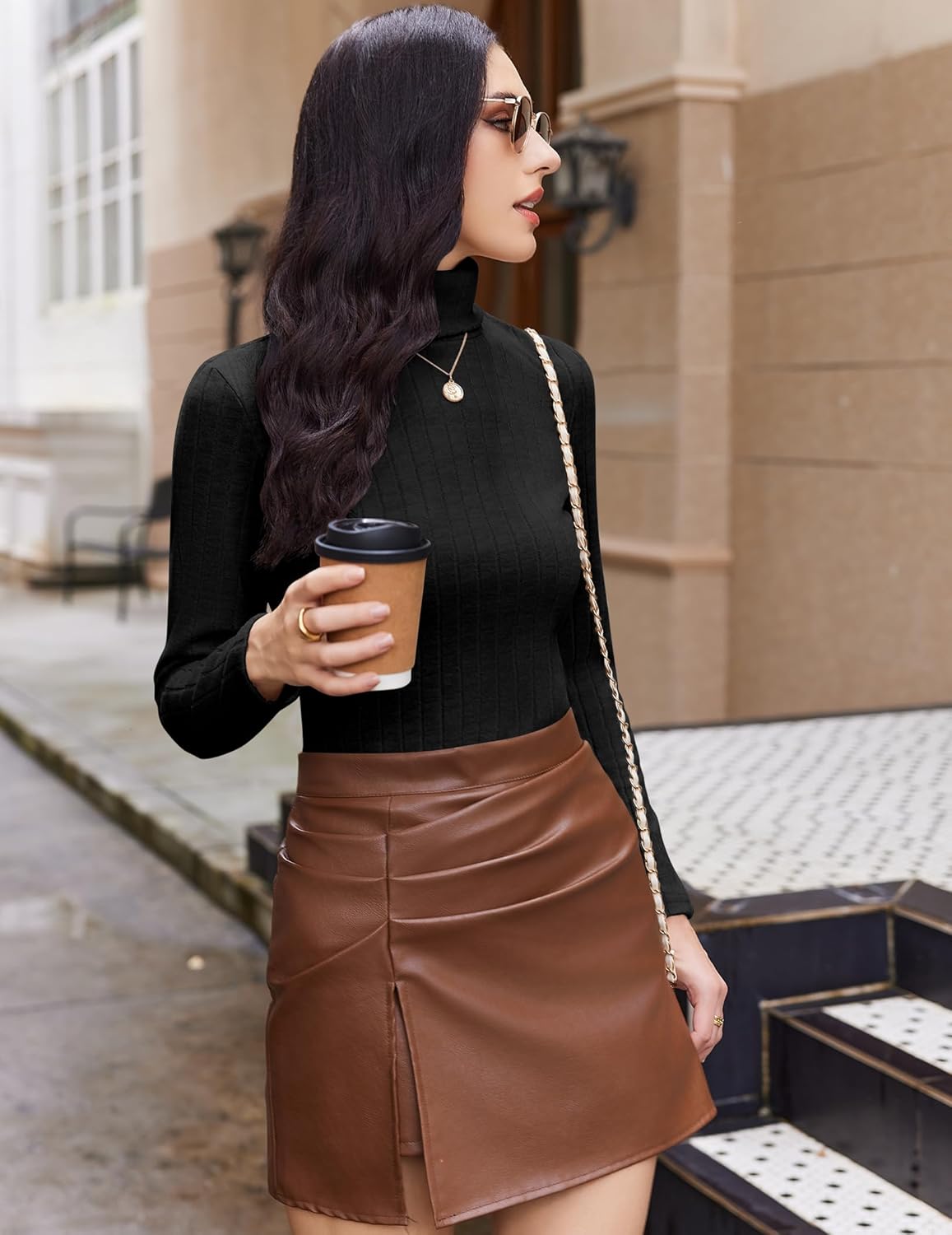 Black ribbed turtleneck long-sleeve top, side profile holding cup