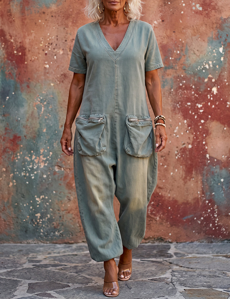 Light blue denim-style V-neck cargo jumpsuit with short sleeves, flap pockets, wide legs